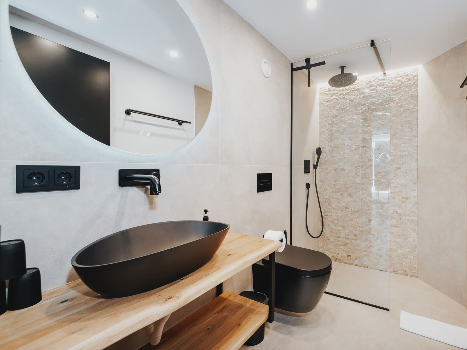 Bad mit schwarzem Waschbecken und Regendusche