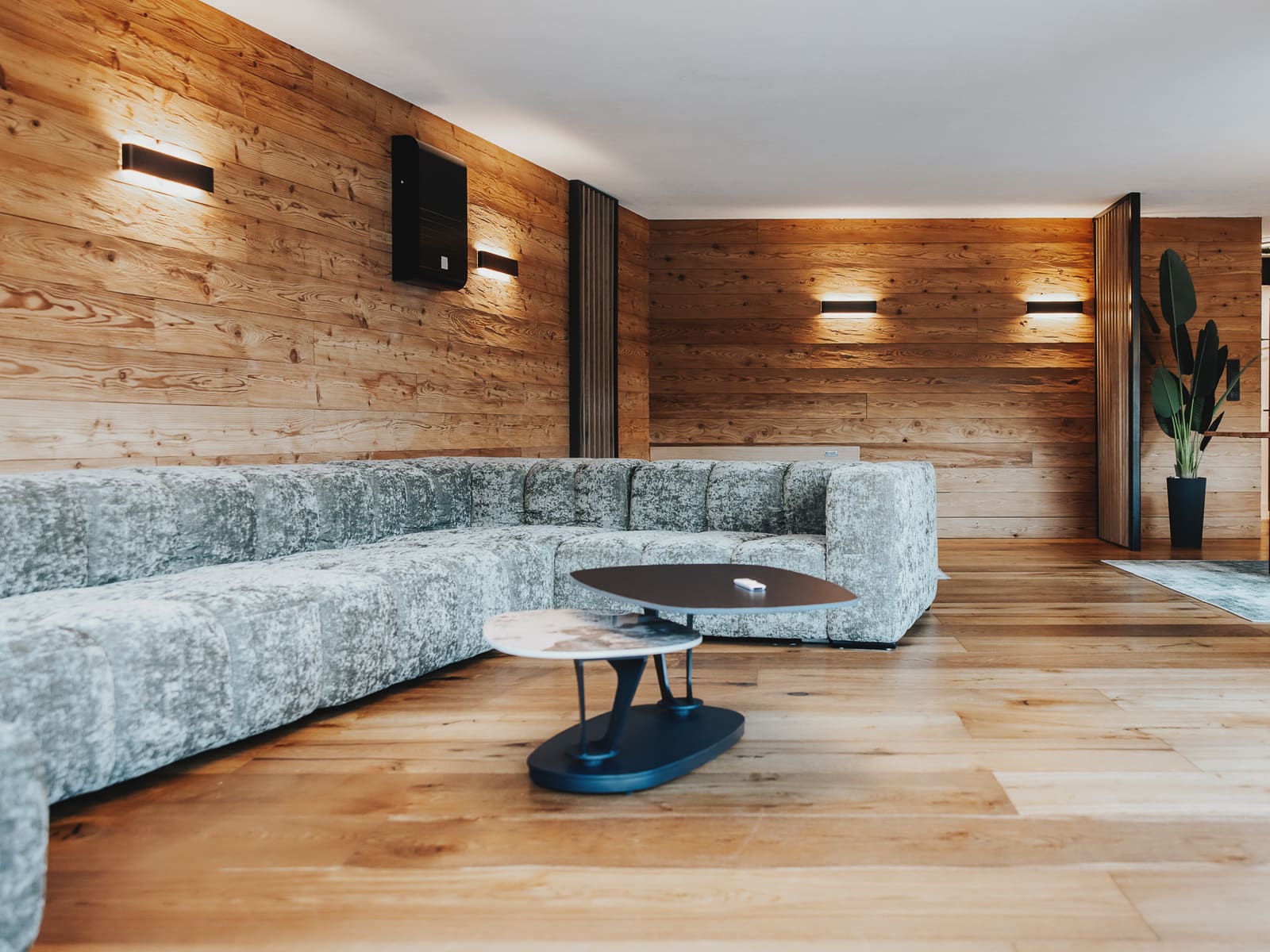 Wohnbereich mit großem Sofa und Altholzwand