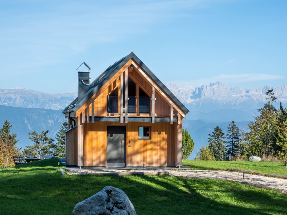 Chalet mit Holzfassade vor den Dolomiten