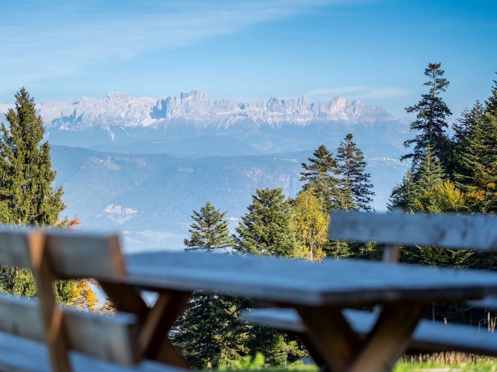 Holztisch im Freien mit Blick auf die Dolomiten