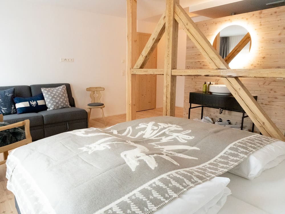 Doppelbett mit Wolldecke und Sofa