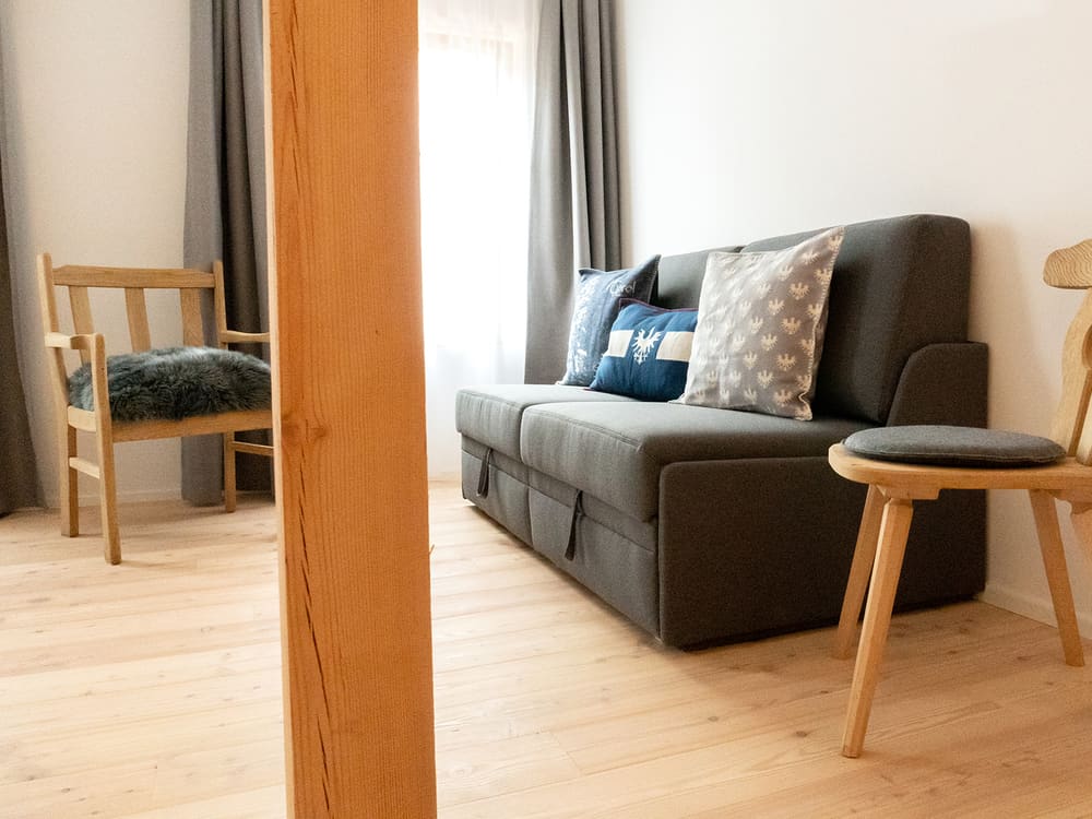 Sitzecke mit Sofa und Holzhocker