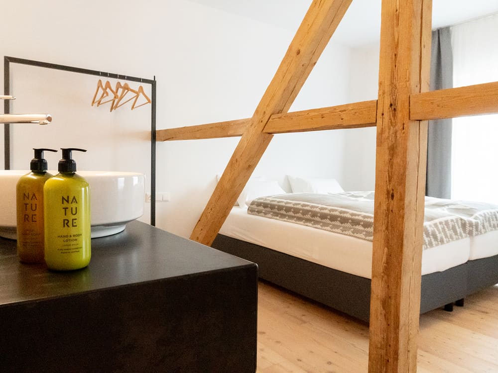 Waschtisch mit Naturkosmetik vor dem Bett