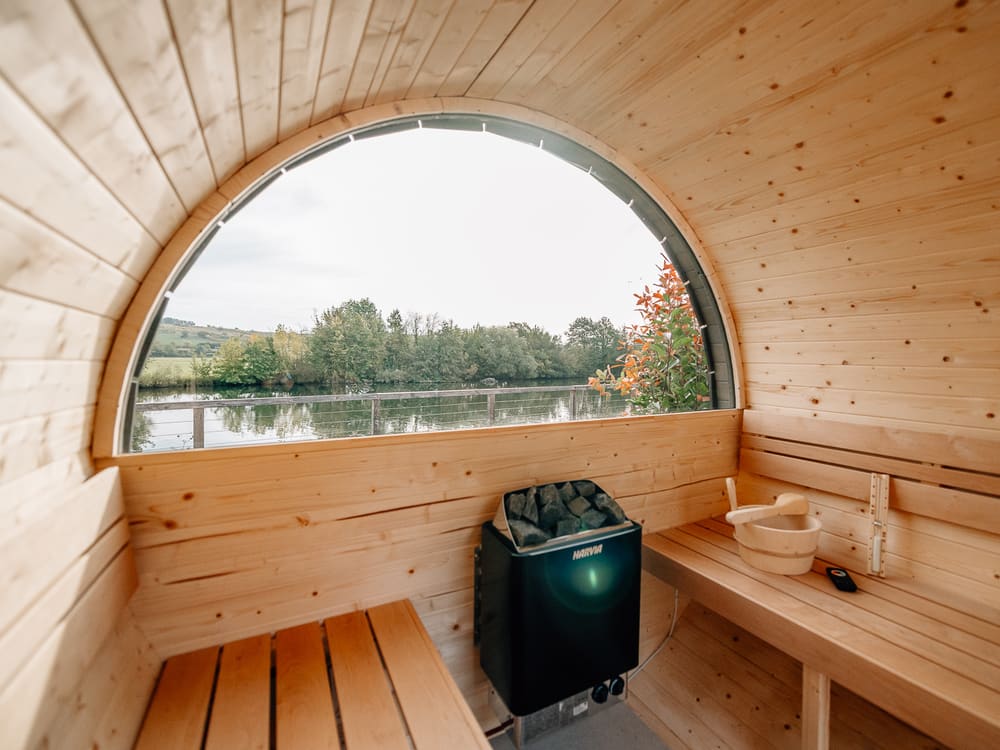 Fasssauna mit Saunaofen und Blick auf den Fluss