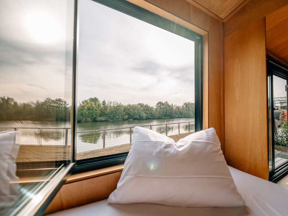 Bett am großen Fenster mit Blick auf den Fluss