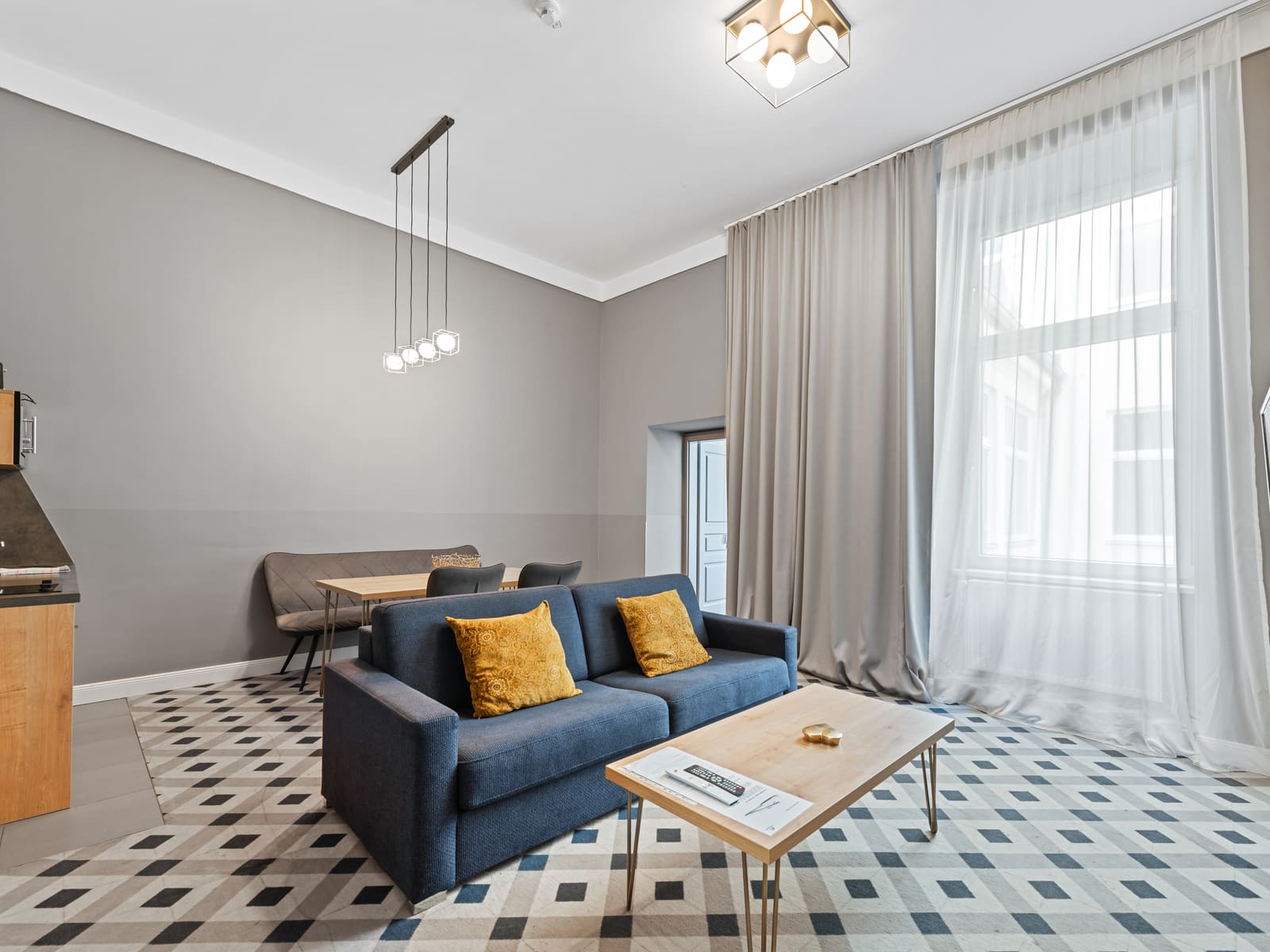 Wohnbereich mit Sofa und hohen Fenstern